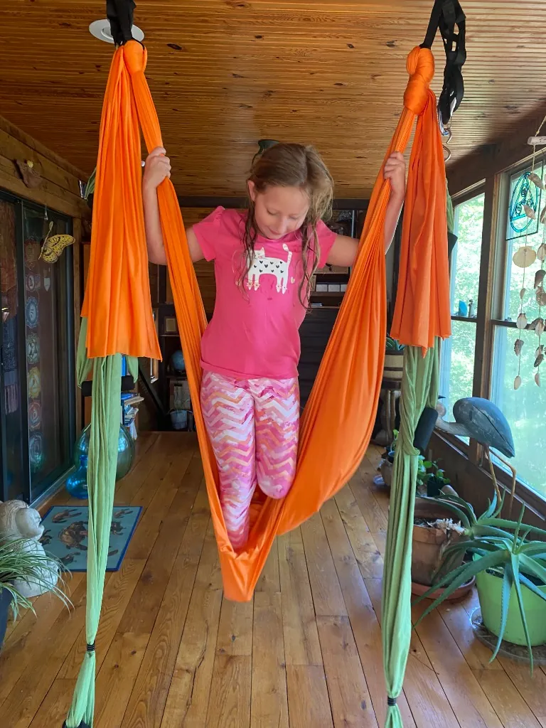 A young girl in an aerial swing