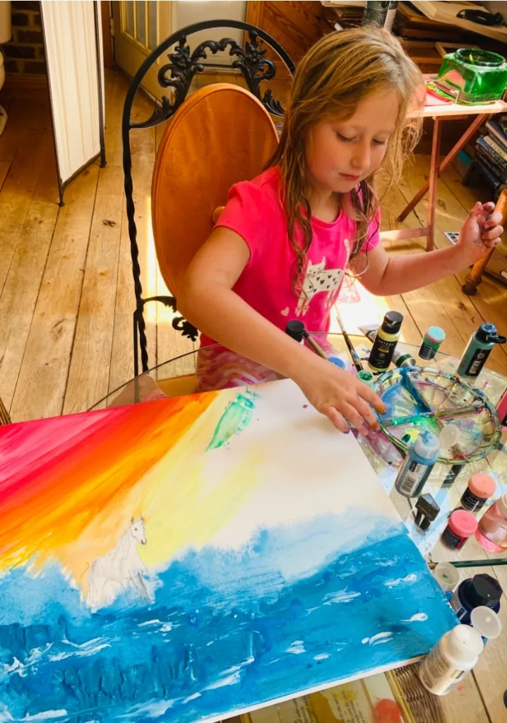 A young girl focused on her painting