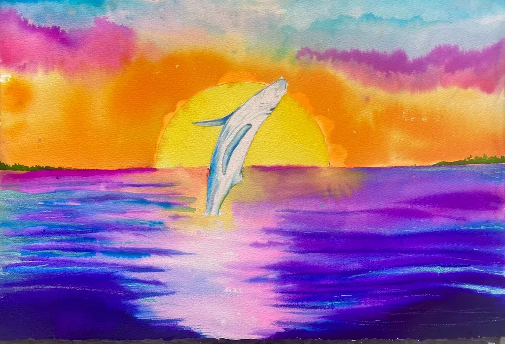 Dolphin jumping out of water at sunset